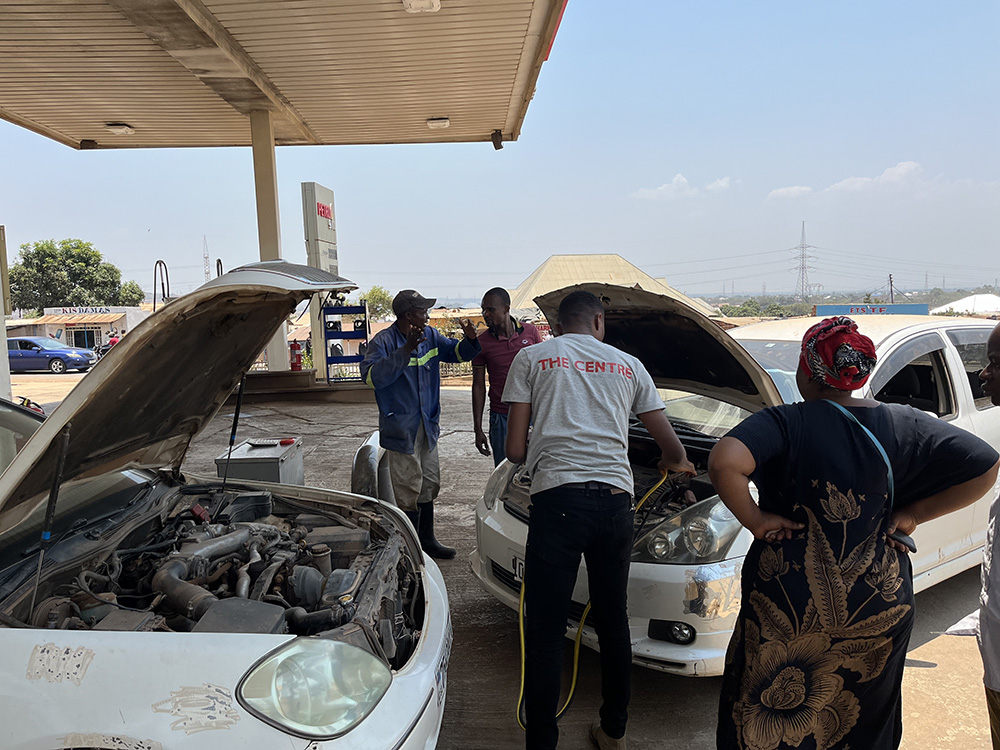 Chadrack fixing a car to get to a family visit on time, Kolwezi, 2024